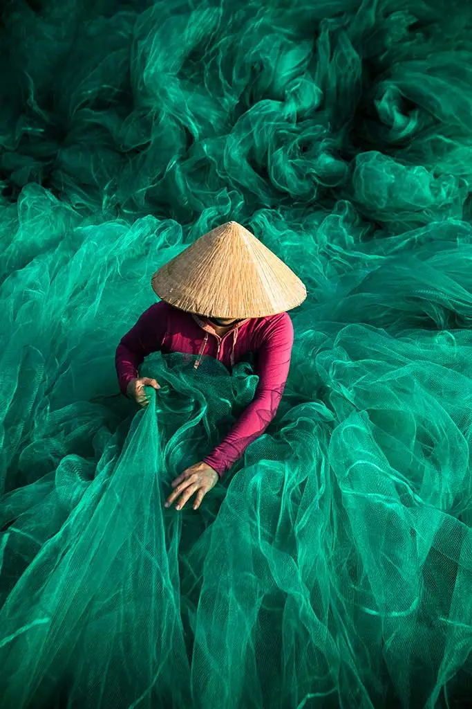 Art in Vietnam - A lady in green fishing nets. Taken in Hoi An