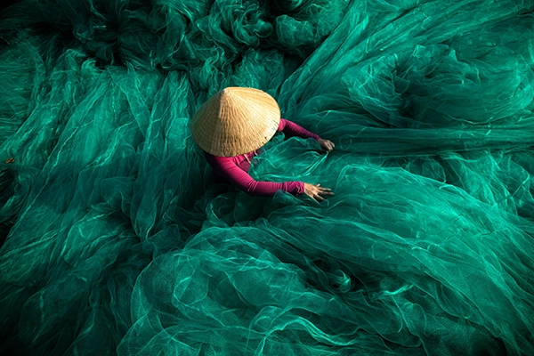 Into the Wave II - Réhahn photography Pêcheur entouré de grands filets verts formant des motifs superposés au Vietnam